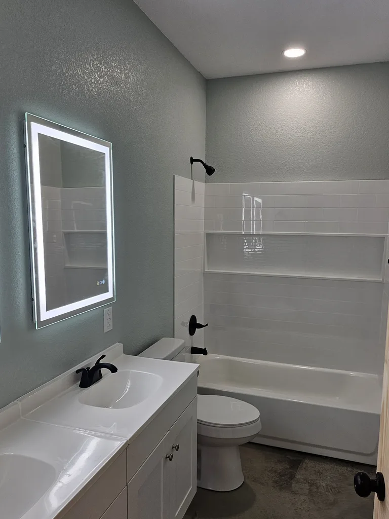 Completed Labette County bathroom update with tiled tub surround and double vanity