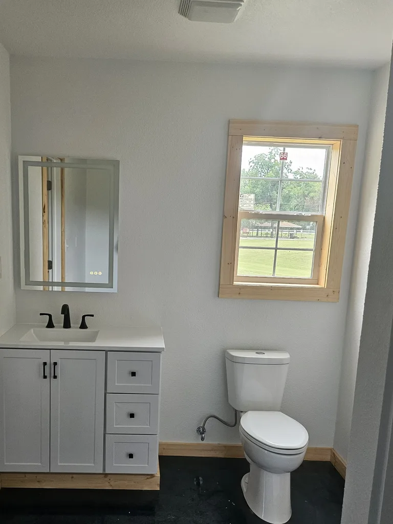 Completed Oswego bathroom update with white vanity and black fixtures